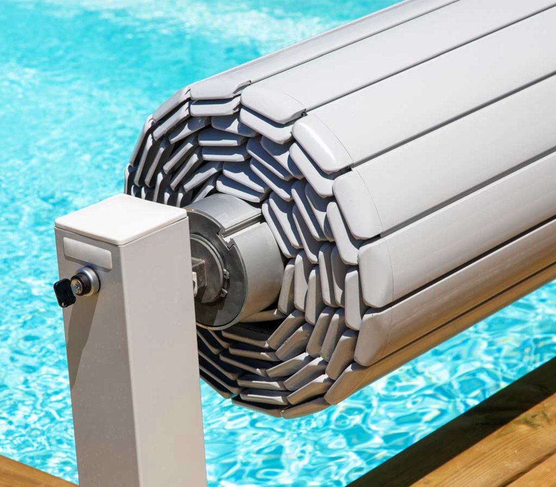 Enrollador de una cubierta de lamas junto al borde de una piscina
